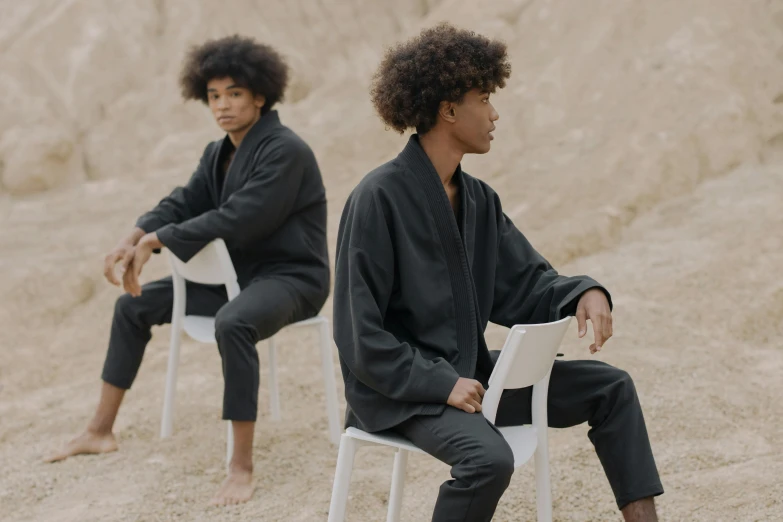 a couple of men sitting on top of a white chair, unsplash, renaissance, samurai with afro, thin black robe, issey miyake, tracksuit