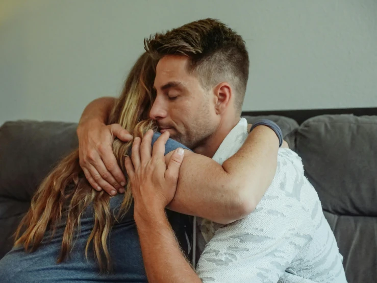 a man and a woman hugging on a couch, pexels contest winner, recovering from pain, owen gent, profile image, background image