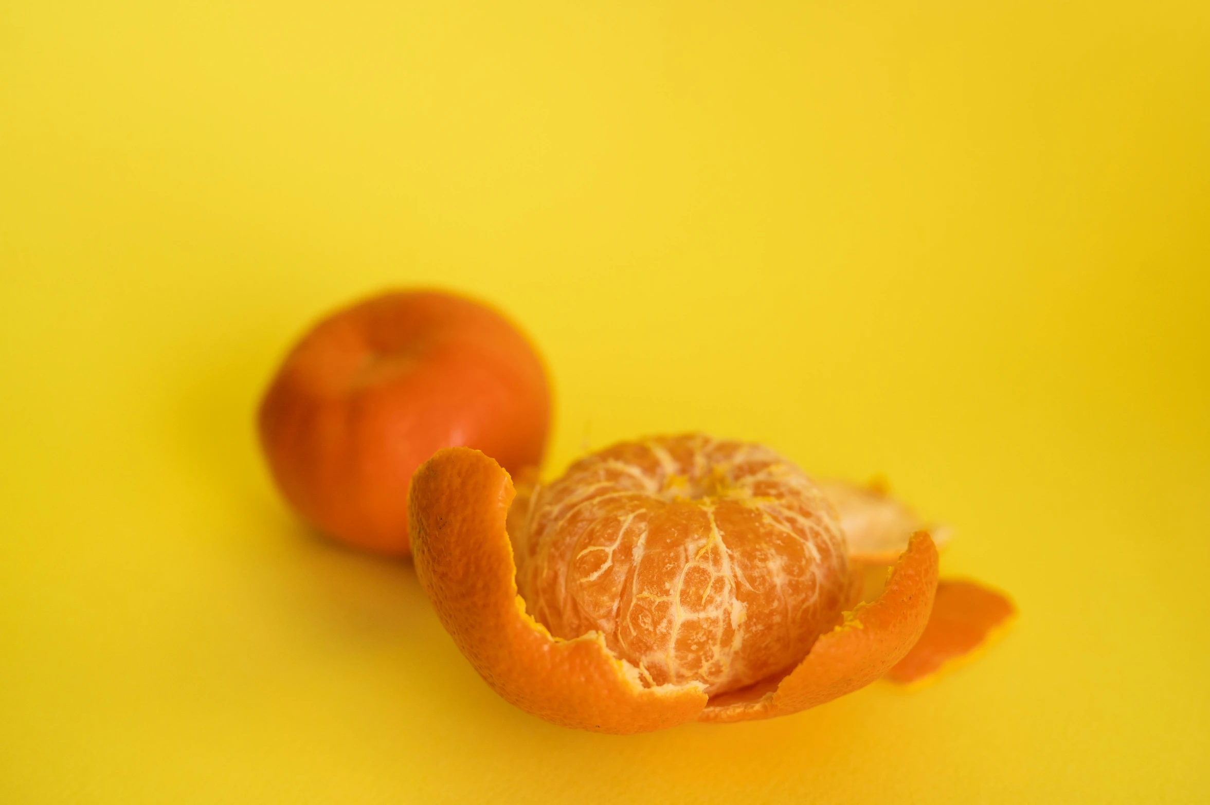 a peeled orange sitting on top of a yellow surface, pexels, 2000s photo, fan favorite, mint, ready to eat