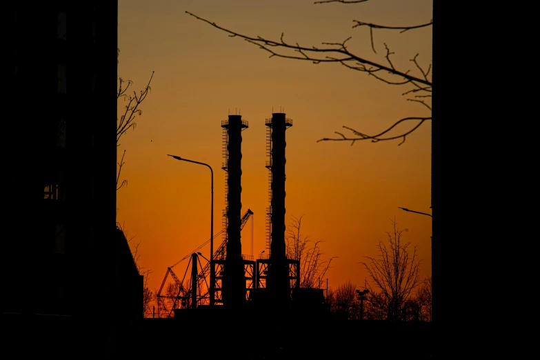 a couple of tall buildings sitting next to each other, by Attila Meszlenyi, pexels contest winner, nuclear art, silhoutte, steel mill, tubes, 2022 photograph