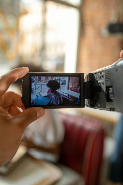 a close up of a person holding a camera, unsplash, video art, talking, lcd screen, long shot from back, shot with sony alpha