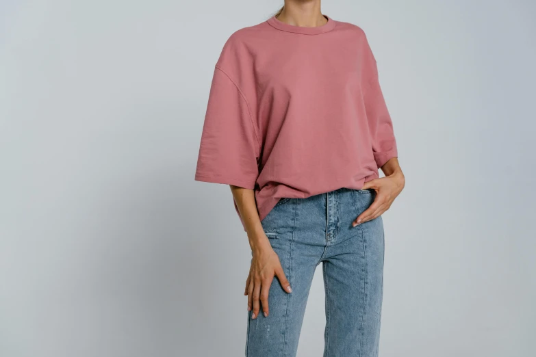 a woman wearing a pink top and jeans, trending on pexels, realism, muted colors. ue 5, baggy, round-cropped, product view