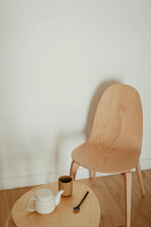 a wooden chair sitting on top of a wooden table, by Harvey Quaytman, unsplash, smooth oval head, nanae kawahara, product display photograph, morning coffee