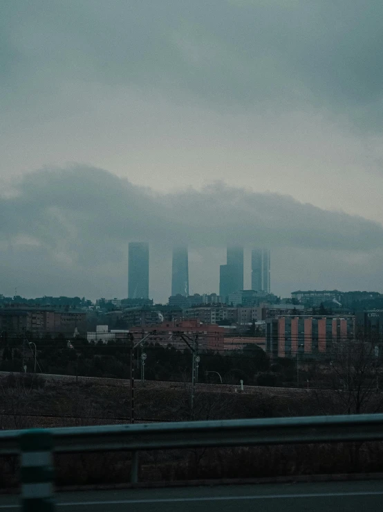 a view of a city on a cloudy day, inspired by Elsa Bleda, pexels contest winner, madrid. extreme long shot, gray fog, low quality photo, spooky photo