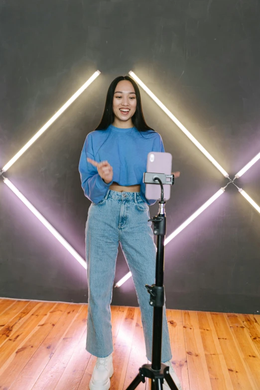 a woman standing in front of a microphone, a hologram, featured on instagram, joy ang, ready to model, standing posture, cool purple slate blue lighting