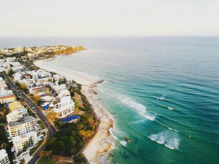 a large body of water next to a beach, by Lee Loughridge, unsplash contest winner, helicopter footage over city, alana fletcher, brooke ashling, coastline