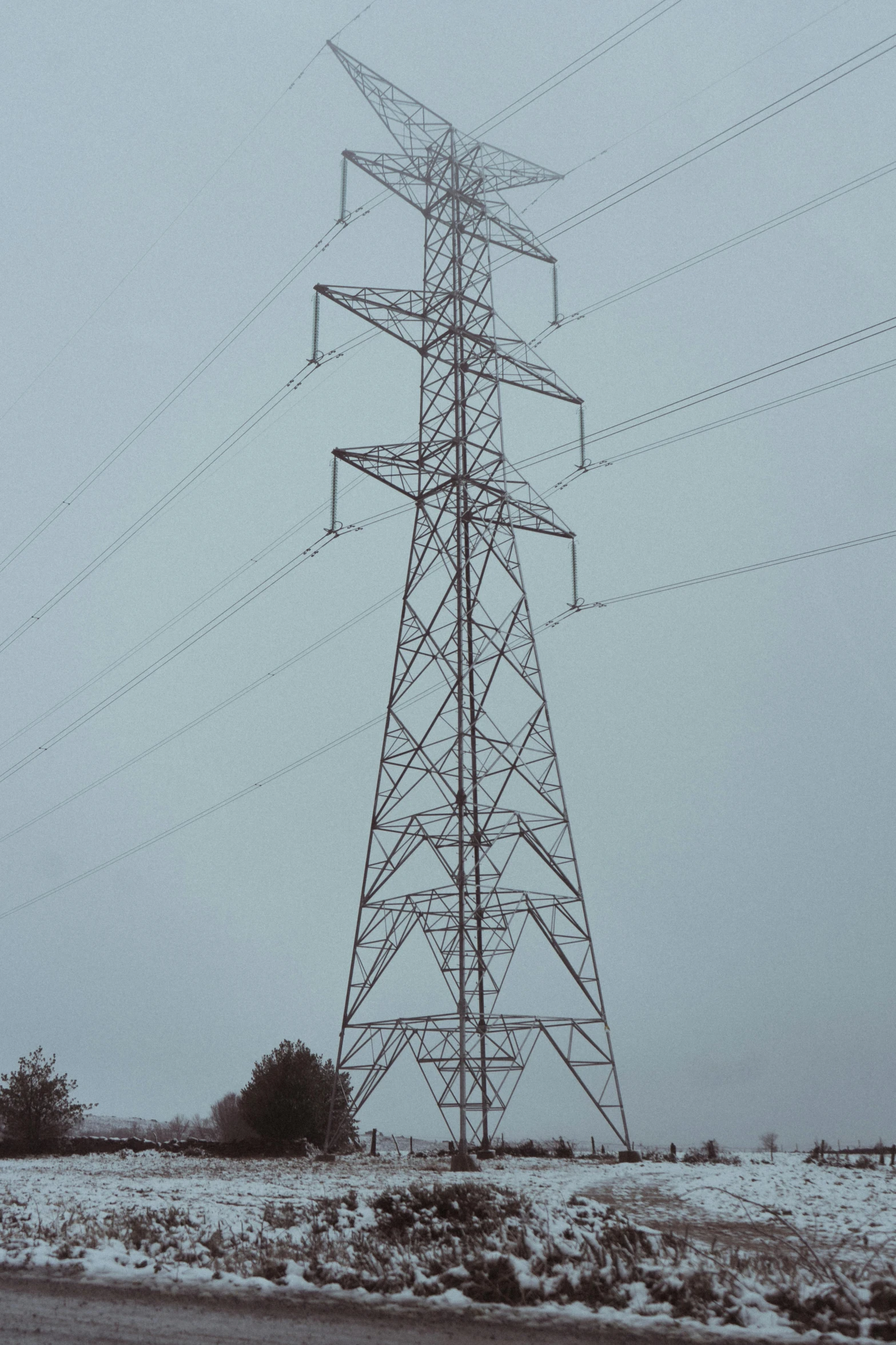 a large tower sitting on top of a snow covered field, inspired by George Fiddes Watt, electrical wiring!, symmetric!!, very poor quality of photography, overcast!!!