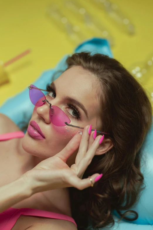 a woman in a pink bikini laying on a bed, an album cover, inspired by Elsa Bleda, trending on pexels, neon sunglasses!, lipstick, official music video, closeup - view