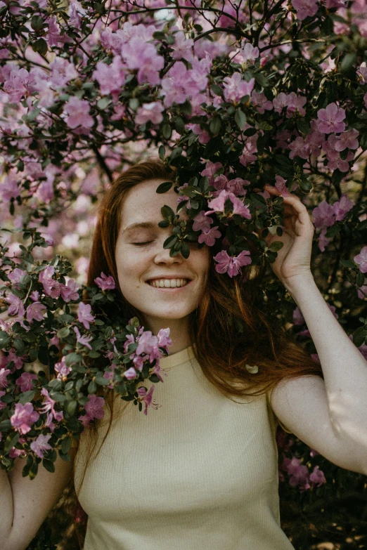 a woman standing in front of a flowering tree, pexels contest winner, renaissance, sadie sink, happy face, humanoid flora, pleasing face