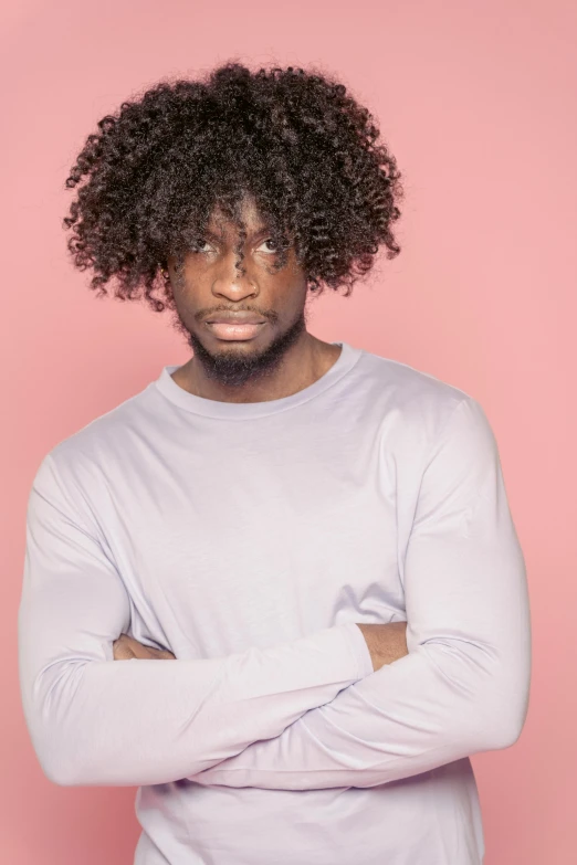 a man with curly hair standing in front of a pink background, inspired by Theo Constanté, pexels contest winner, grey skinned, plain background, riyahd cassiem, big hair