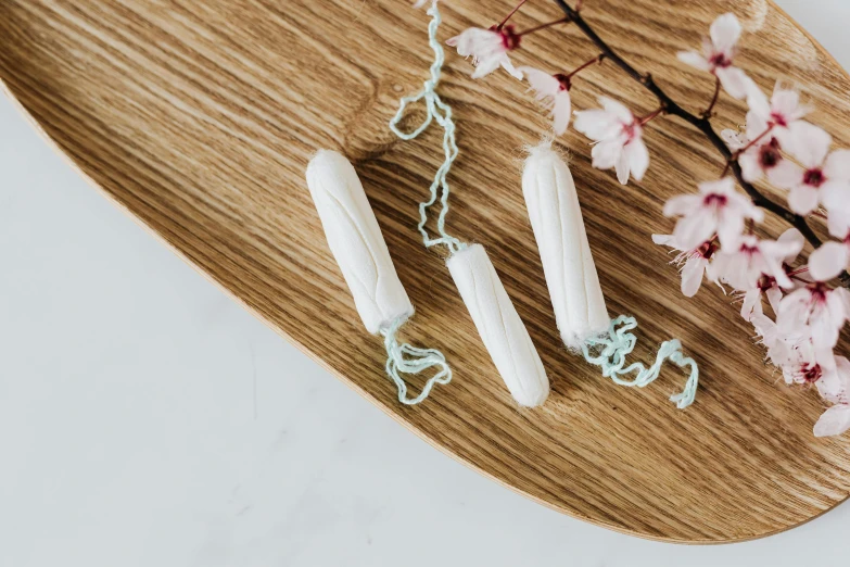 a close up of a white object on a wooden plate, floggers, vines. tiffany blue, threes, official product photo