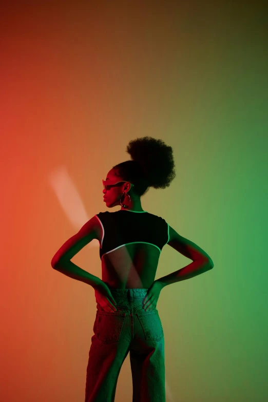 a woman standing with her hands on her hips, by Clifford Ross, trending on pexels, afrofuturism, with a ponytail, luminescent colors, half-turned lady in evening gown, color block