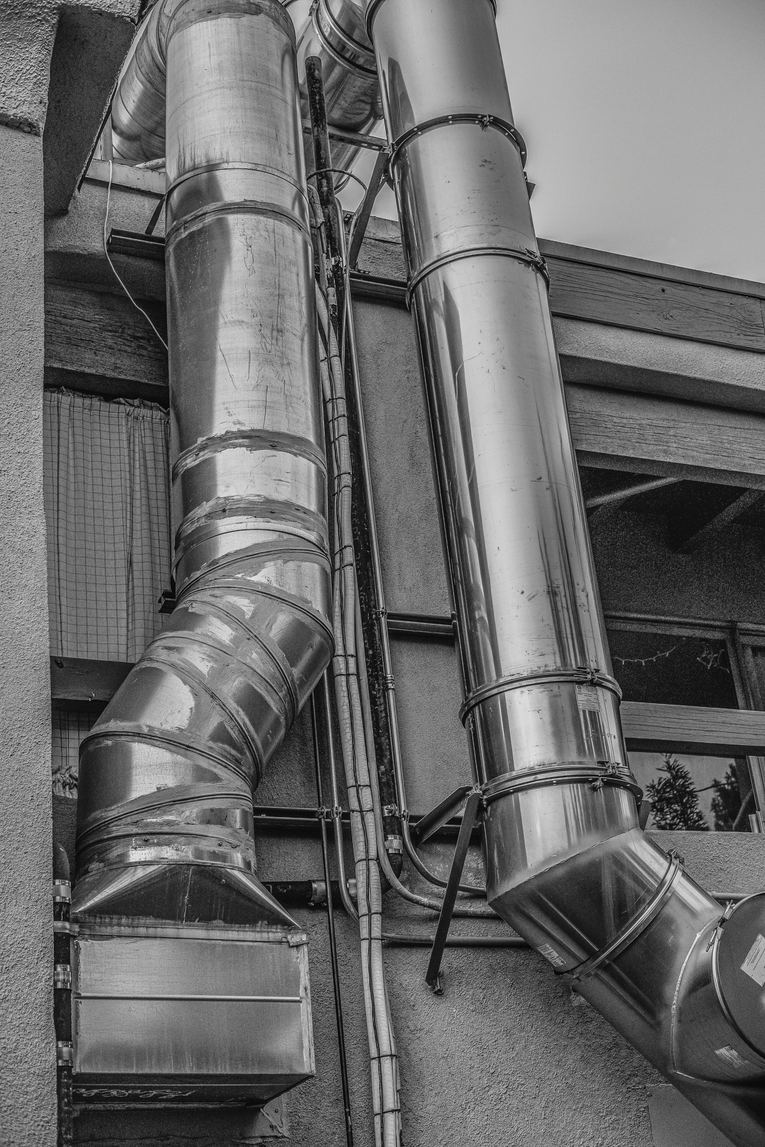 a tall metal pipe sticking out of the side of a building, a black and white photo, by Sven Erixson, unsplash, smoking vessels, made out of shiny silver, machinery, colours