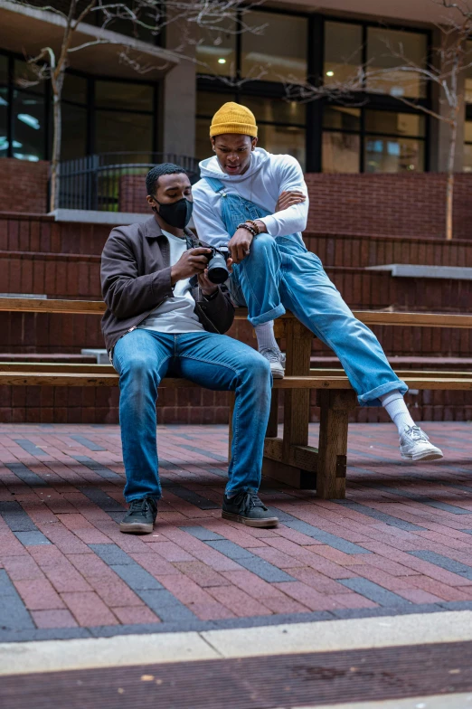 a couple of men sitting on top of a wooden bench, a picture, by Washington Allston, unsplash, baggy jeans, at college, ( ( theatrical ) ), jemal shabazz