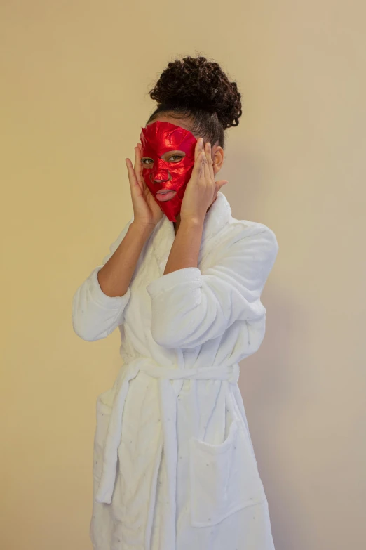 a woman wearing a white robe and a red mask, photoshoot for skincare brand, glitter, rectangle, all red