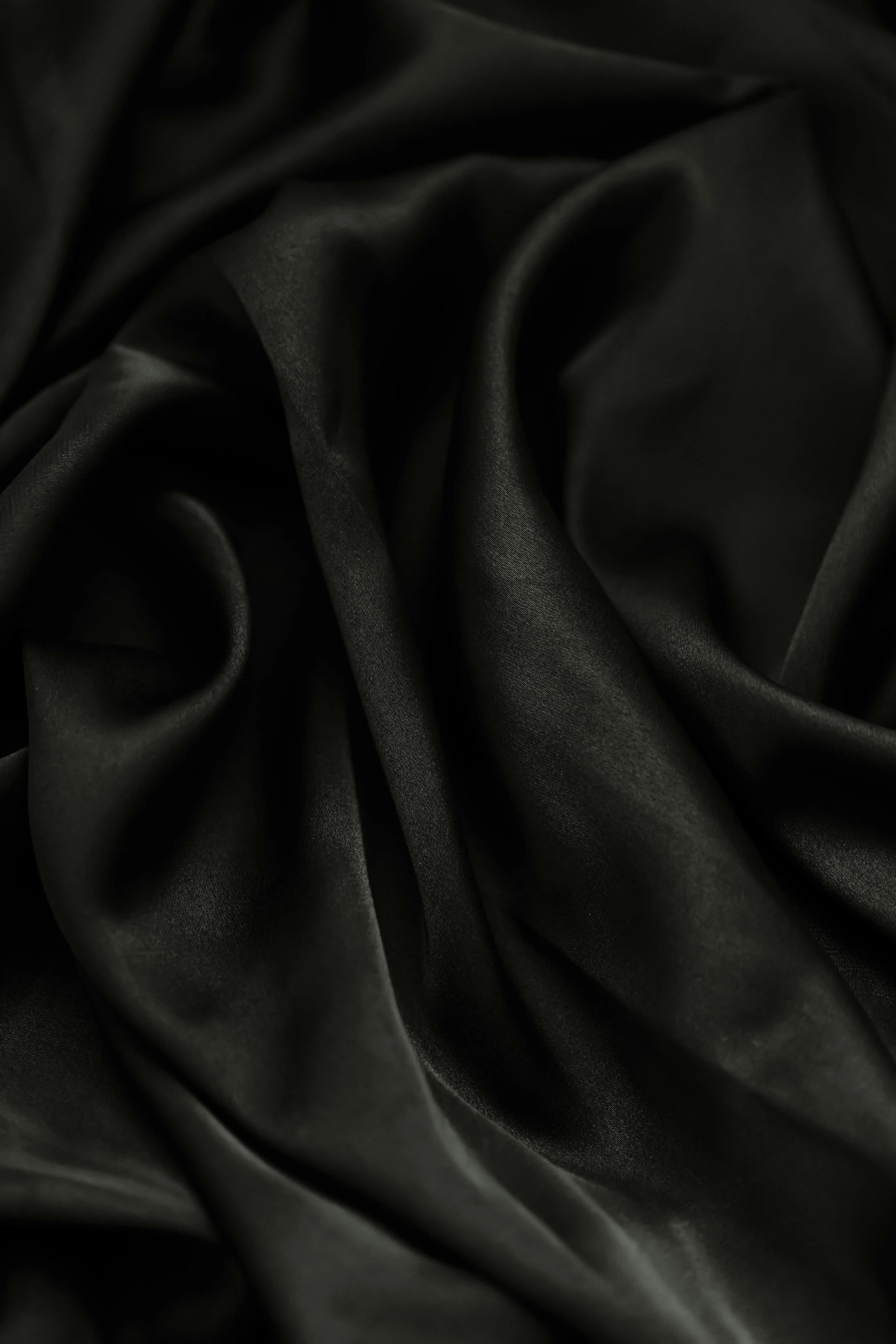 a close up of a black silk fabric, zoomed out to show entire image, detailed product image, dark natural glow, satin