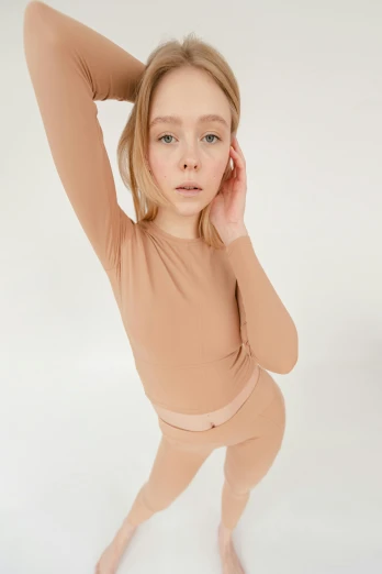 a young girl posing for a picture in a tan leo leo leo leo leo leo leo leo leo leo leo leo leo leo leo, inspired by Vanessa Beecroft, thumbnail, sleepwear, leotard and leg warmers, full product shot