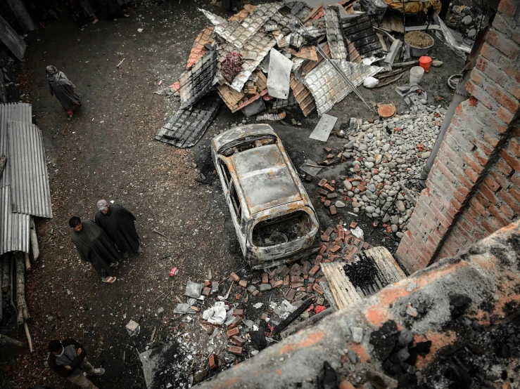 a burnt out car sitting on top of a pile of rubble, a photo, bird eye view, realistic photo”, february), thumbnail