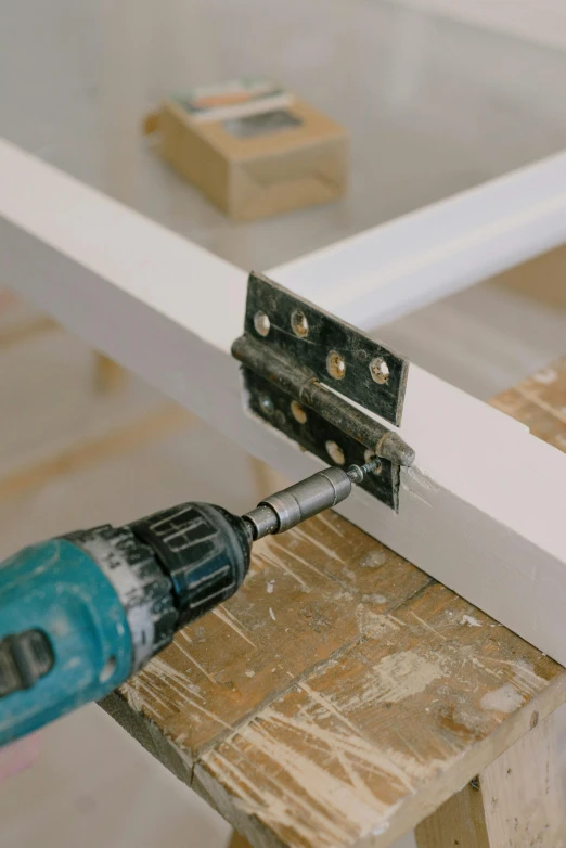 a close up of a drill on a piece of wood, inspired by Jan Kupecký, unsplash, furniture, square, scaffolding, white