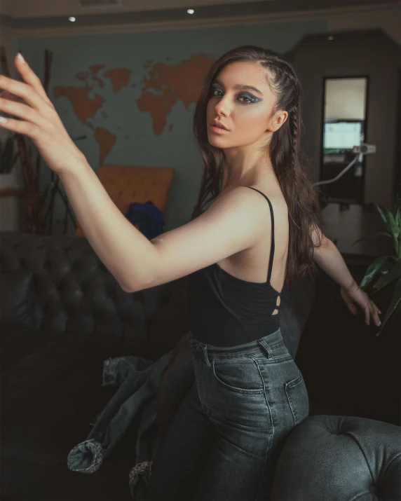 a beautiful young woman sitting on top of a couch, inspired by Elsa Bleda, trending on pexels, selfie photo, wearing a black bodysuit, standing in corner of room, t pose