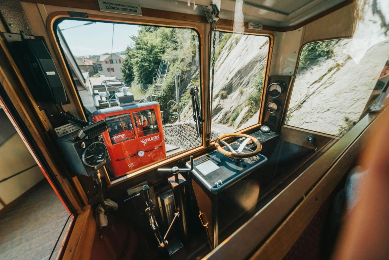 a red train traveling down train tracks next to a forest, a portrait, by Tobias Stimmer, unsplash, art nouveau, ship interior, chairlifts, view from a news truck, wellington