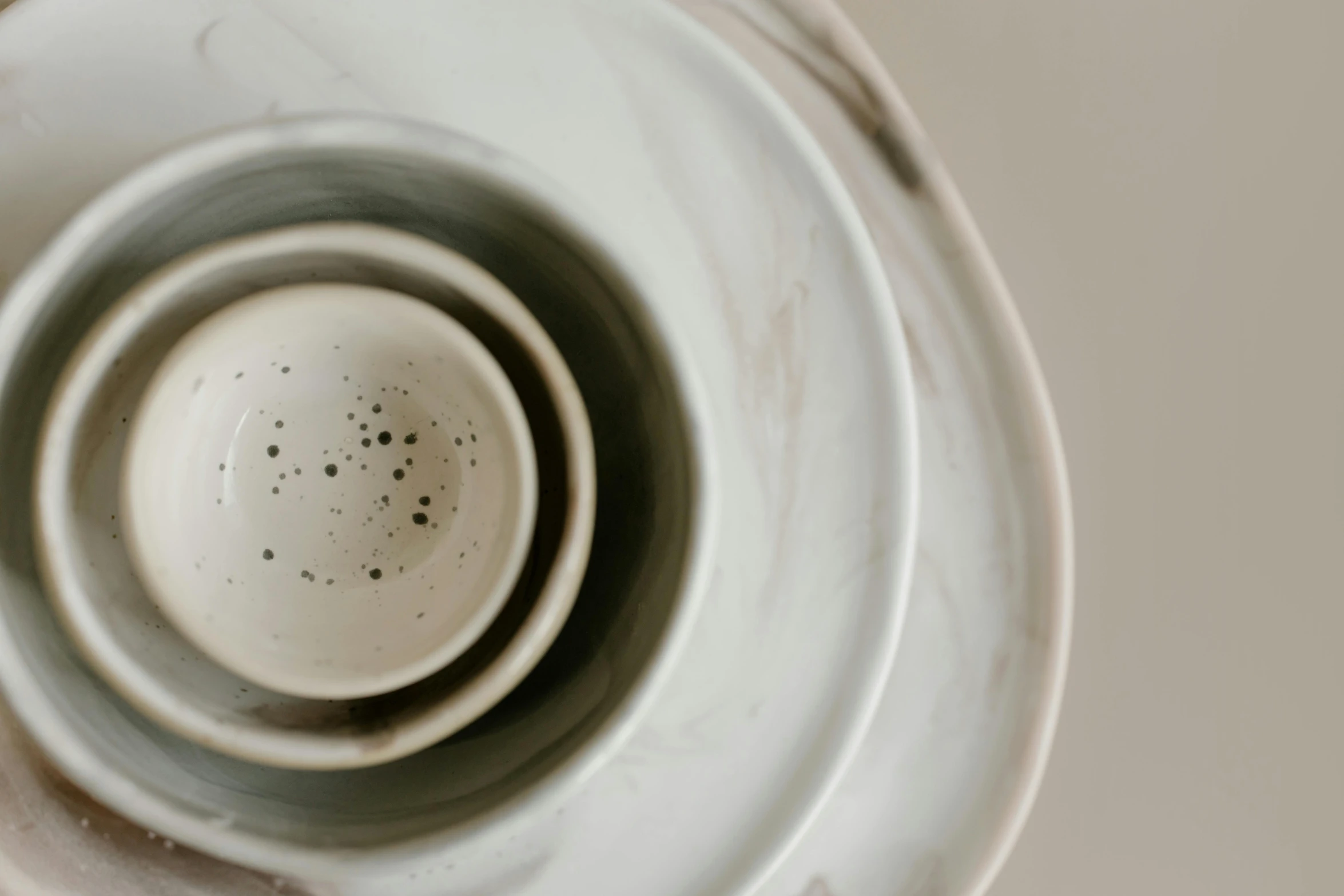 a white bowl sitting on top of a white plate, a marble sculpture, inspired by Lewis Henry Meakin, trending on unsplash, process art, various sizes, close up shot from the top, white and grey, vessels