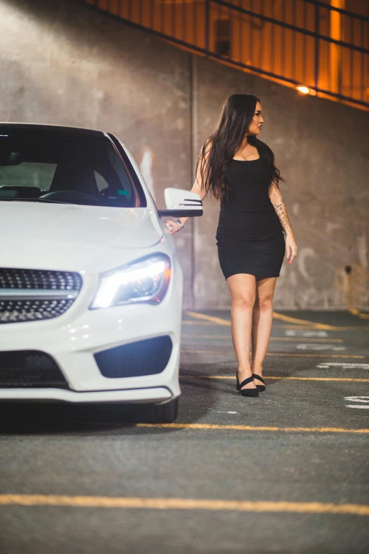 a woman in a black dress standing next to a white car, square, mercedez benz, profile image, f/1.4