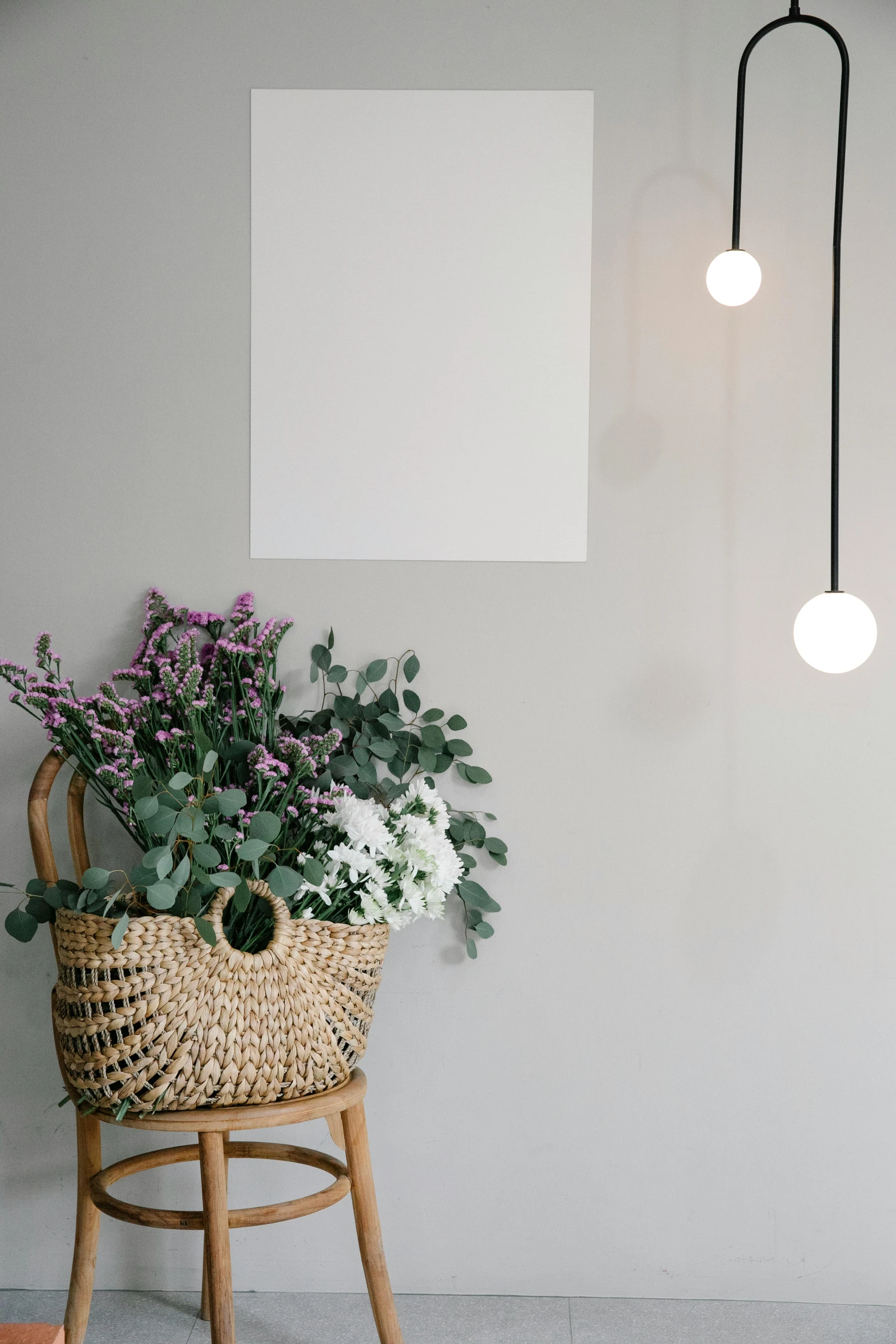 a basket sitting on top of a wooden chair next to a plant, inspired by Constantin Hansen, pexels contest winner, light and space, lights on ceiling, hanging out with orbs, with a white background, with flowers