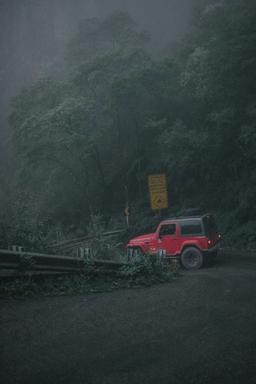 a red truck parked on the side of a road, by Elsa Bleda, realism, cloud forest, jeep wrangler, fallen trees, on a mountain