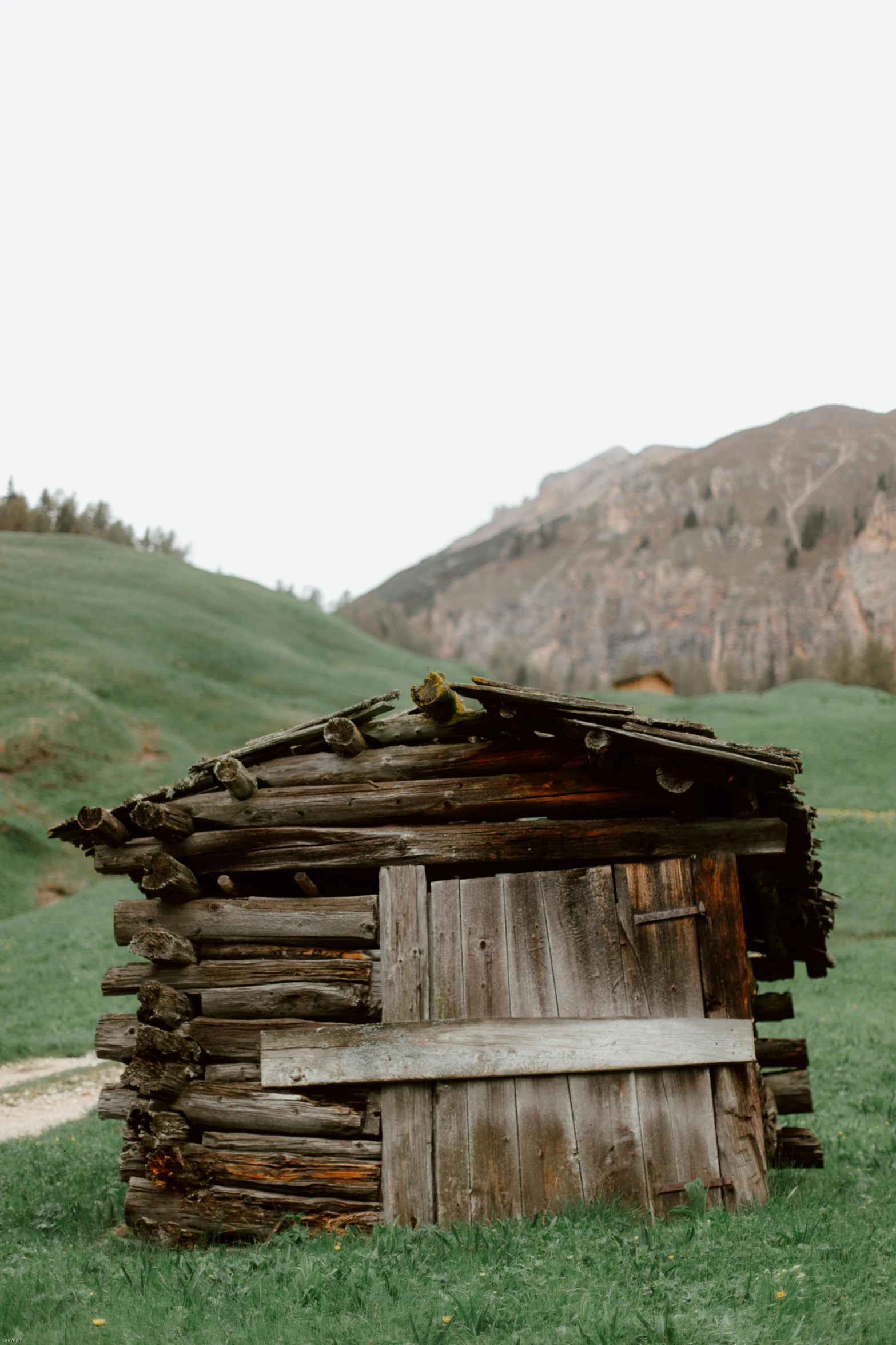 an old outhouse in a field with mountains in the background, a picture, pexels contest winner, renaissance, log cabin beneath the alps, tiny house, hd footage, cute photo