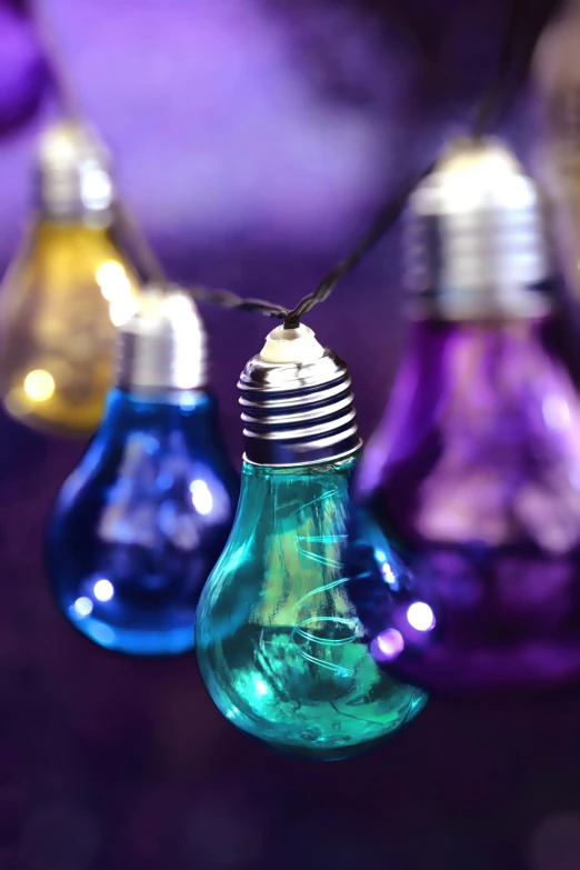 a group of light bulbs hanging from a string, iridescent colours, purple, multicoloured, lightning in a bottle