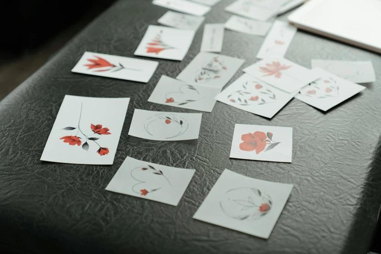 a table that has a bunch of cards on it, a tattoo, trending on pexels, serial art, red flowers, unframed, 9 9 designs, delicate embellishments