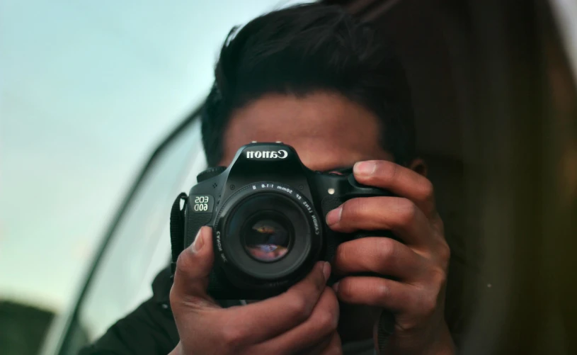 a person taking a picture with a camera, all looking at camera, close to the camera, front facing the camera, telephoto