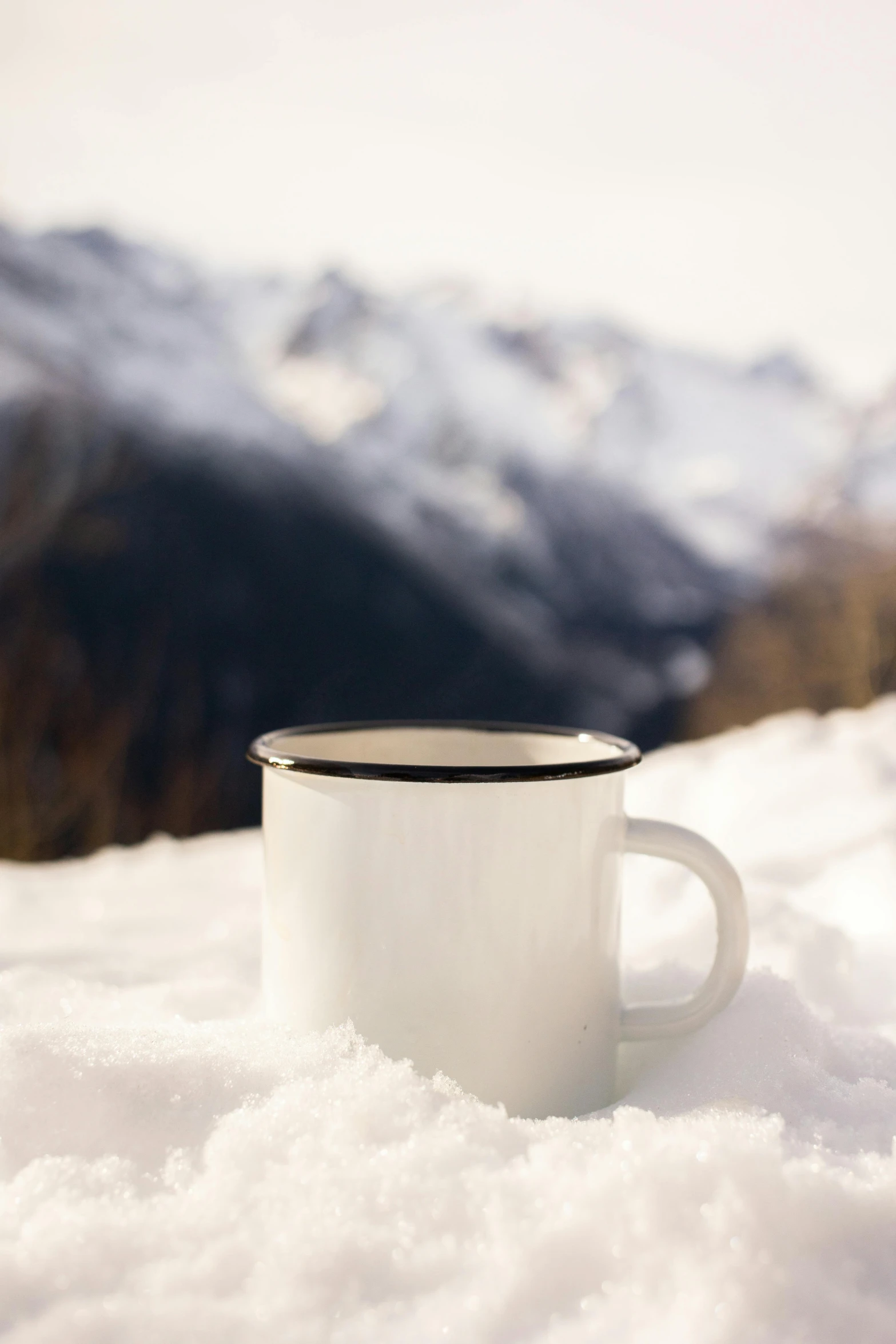 a cup of coffee sitting on top of snow covered ground, in the mountains, detailed product image, hero shot, zinc white