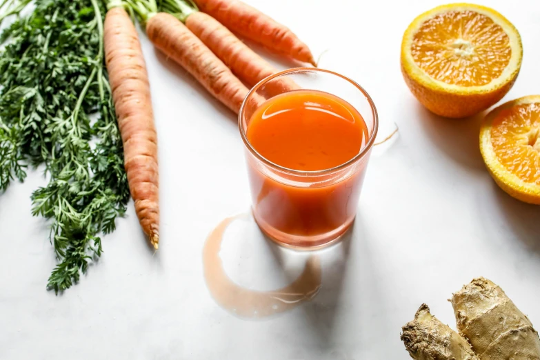 a glass of carrot juice next to sliced oranges and ginger, unsplash, veggies, white bg, background image, hop cone juice