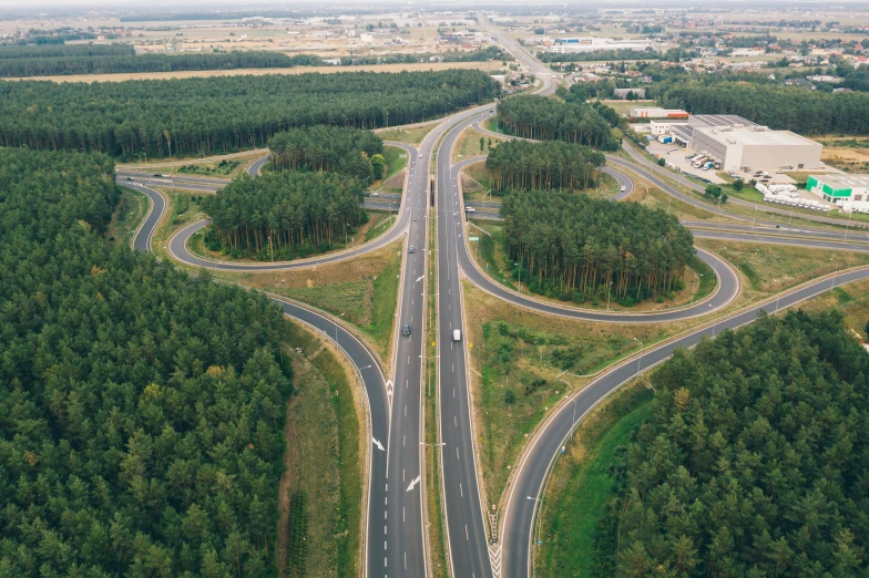 an aerial view of a highway in the middle of a forest, by Adam Marczyński, renaissance, helmond, in the background, thumbnail, intersection