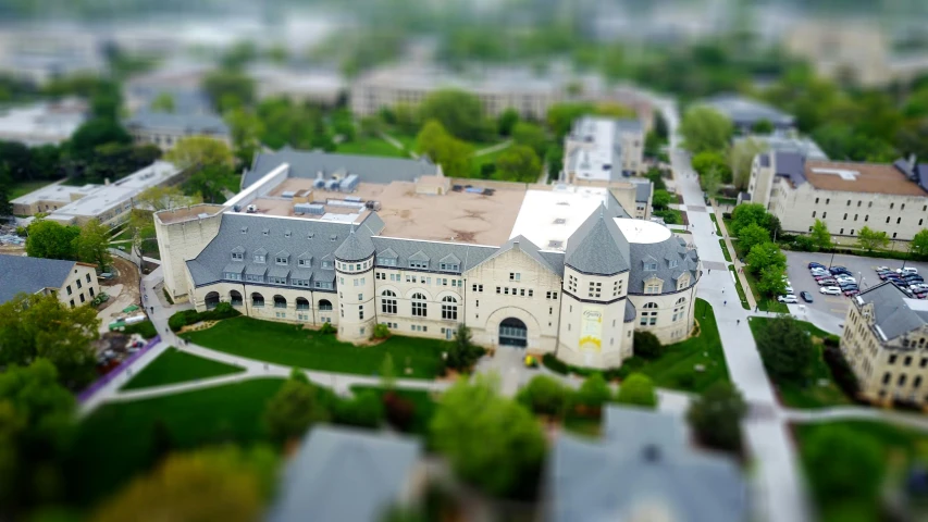 a large building sitting on top of a lush green field, a tilt shift photo, by Kurt Roesch, academic art, drone photograpghy, castle, at college, center model buildings