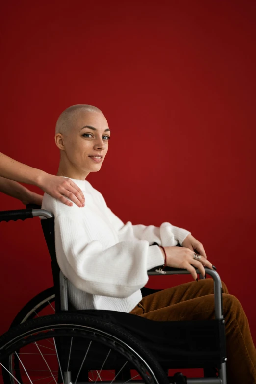 a woman pushing a man in a wheelchair, an album cover, trending on unsplash, antipodeans, portrait of bald, red colored, confident pose, portrait sophie mudd