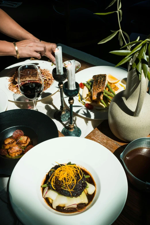 a close up of a plate of food on a table, renaissance, wine, dark hues, overhead sun, inside a grand