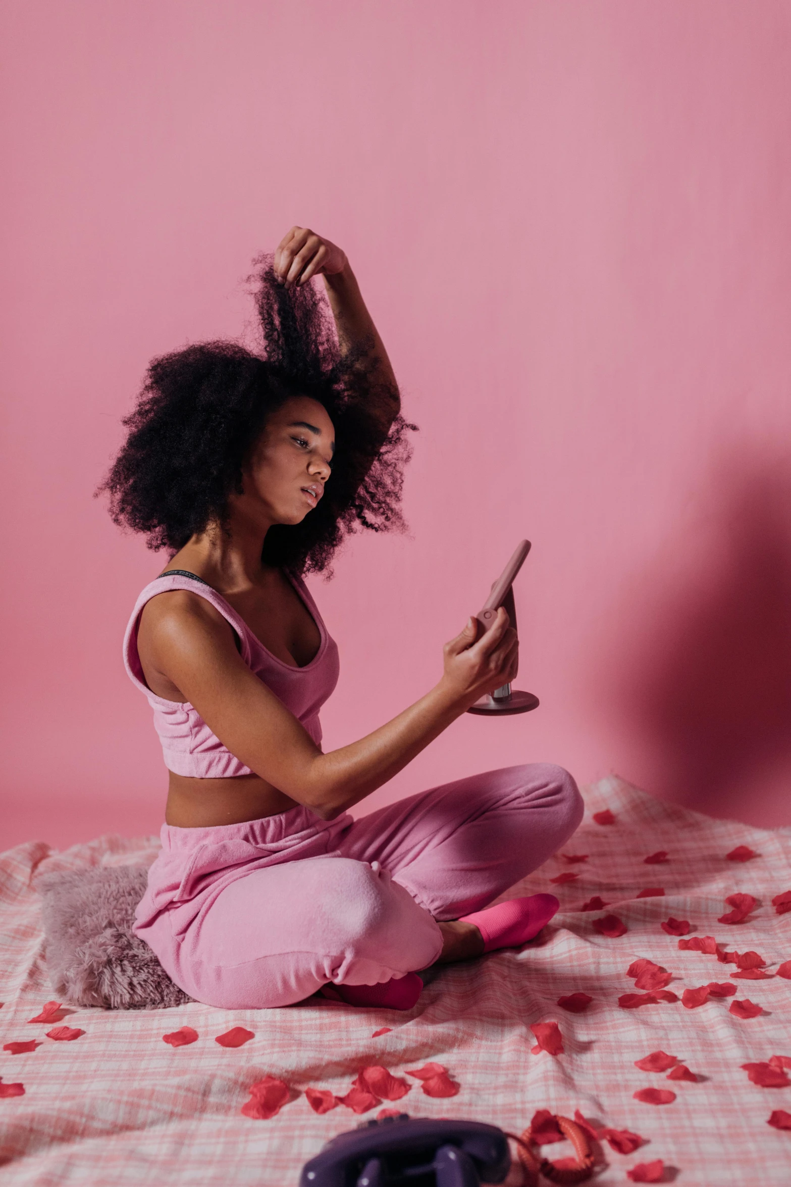 a woman sitting on a bed using a cell phone, trending on pexels, renaissance, tight gigantic pink curls, afro comb, heartbreak, hearts