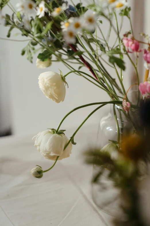 a vase filled with flowers sitting on top of a table, inspired by François Boquet, unsplash, close up shot from the side, tufted softly, white sweeping arches, colour photograph