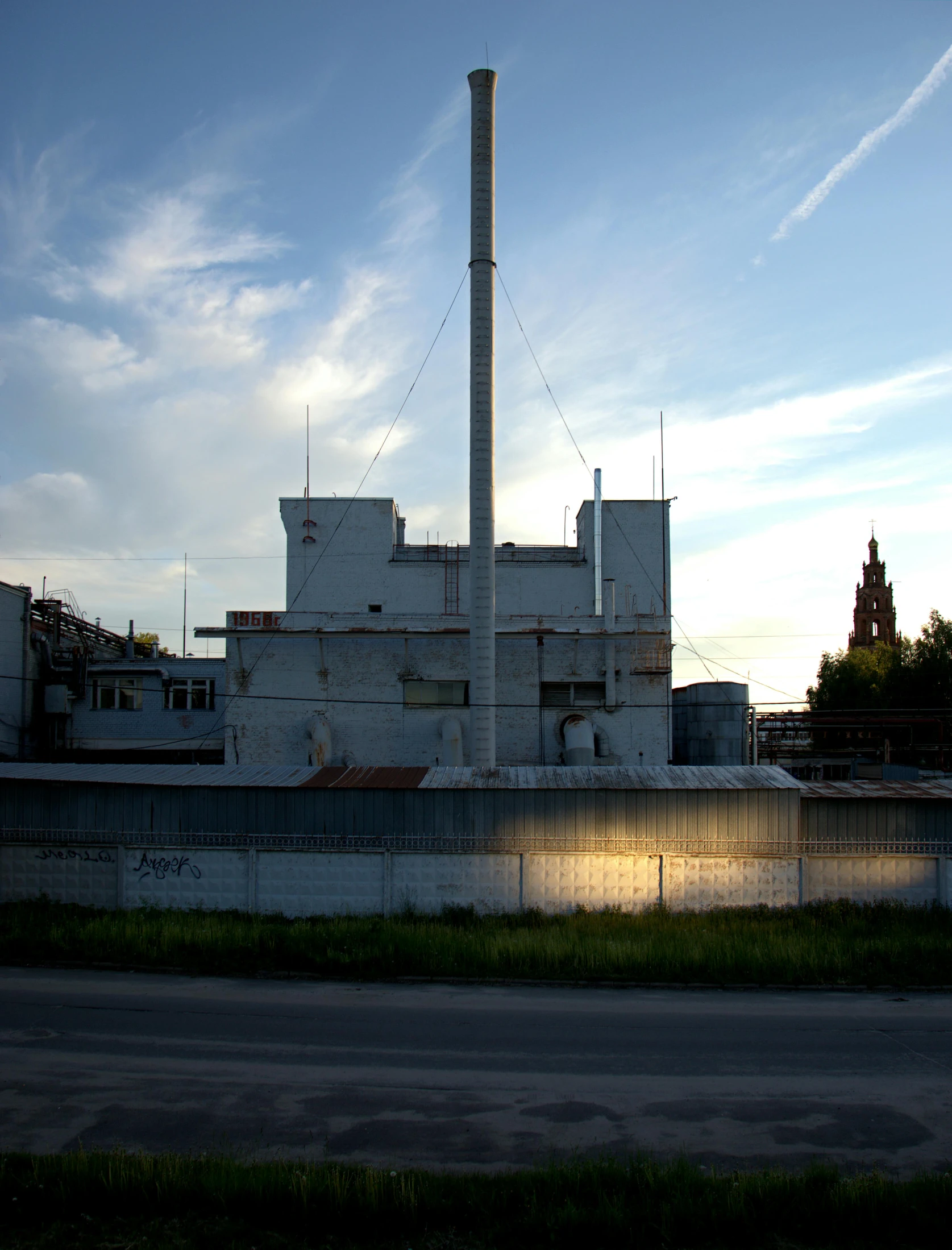 a large white building sitting on the side of a road, by Jan Tengnagel, industrial saliva ooze, spire, low quality photo, warsaw