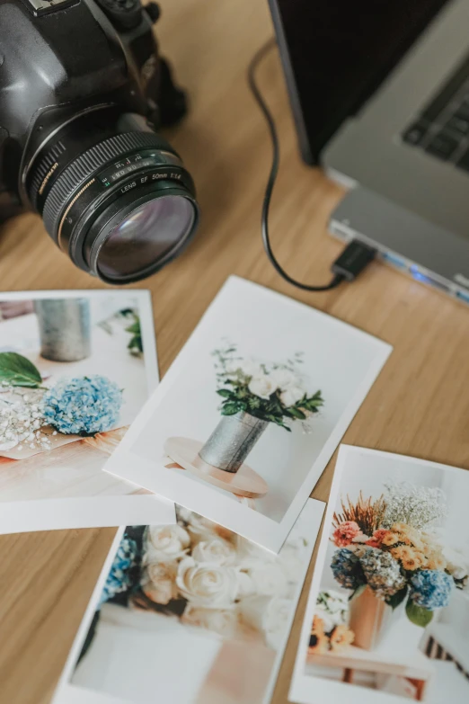 a laptop computer sitting on top of a wooden desk, a polaroid photo, trending on pexels, art photography, flowers, cameras lenses, inspect in inventory image, hasselblad photo