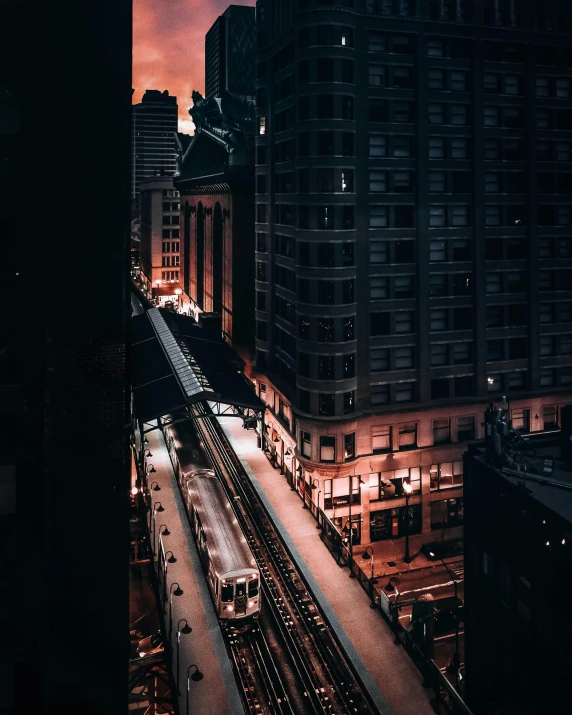 a train traveling through a city at night, by Adam Rex, pexels contest winner, chicago, instagram story, wide high angle view, late morning