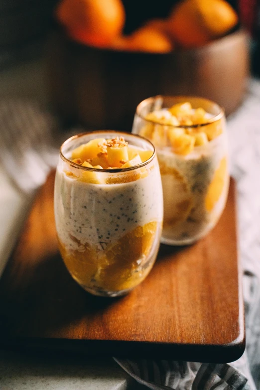 two glasses of chia pudding with oranges in the background, unsplash, renaissance, sri lanka, pineapple, square, full-body