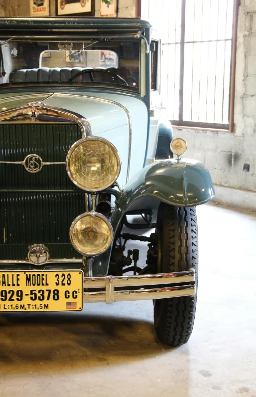 an old car is parked in a garage, headlights turned on, 1 9 3 0 style, julia hill, preserved historical