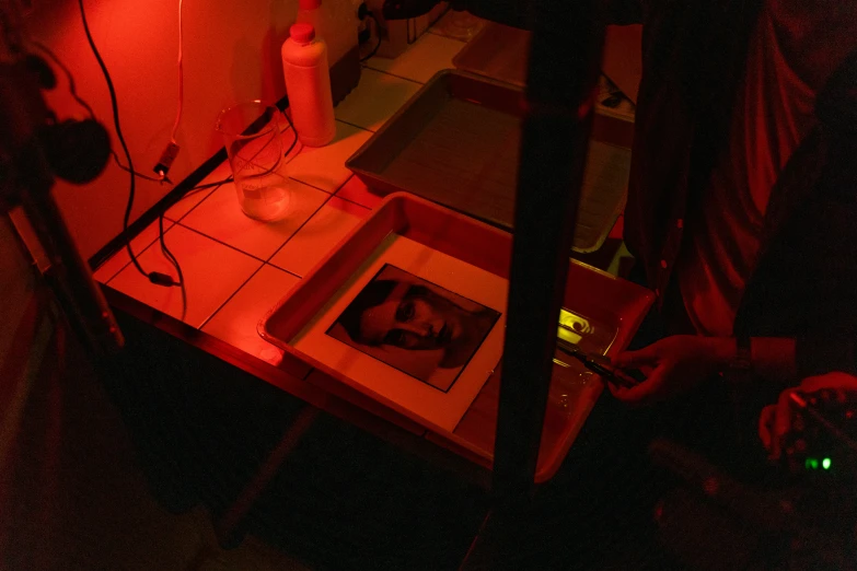 a man playing a video game in a dimly lit room, a silk screen, by Daniel Lieske, process art, red laser scanner, in a lab, a seance, instagram photo