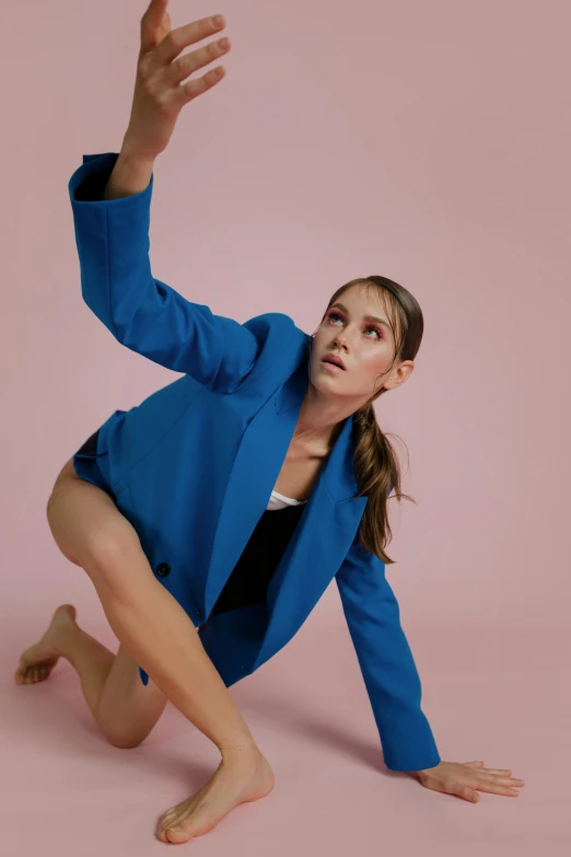 a woman in a blue suit reaching up to catch a frisbee, inspired by Elizabeth Polunin, thoughtful pose, wearing leotard, press shot, harmony blue jacket