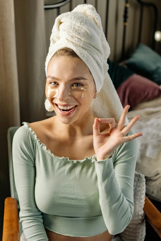 a woman sitting in a chair with a towel on her head, a picture, trending on pexels, renaissance, winking, silicone skin, manuka, deep dimples