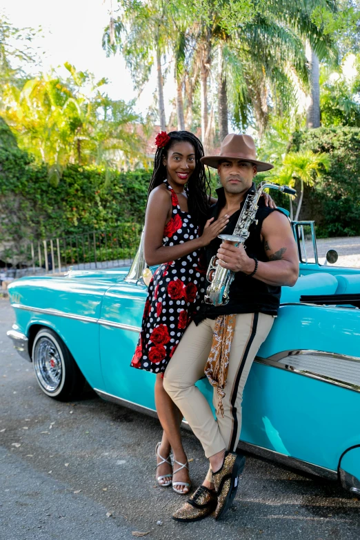 a man and a woman standing next to a blue car, an album cover, pexels contest winner, happening, cuban setting, various posed, musician, california;